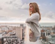Sasha Digiulian looks out over a city skyline from a rooftop, part of Bentley's Bentayga social campaign.