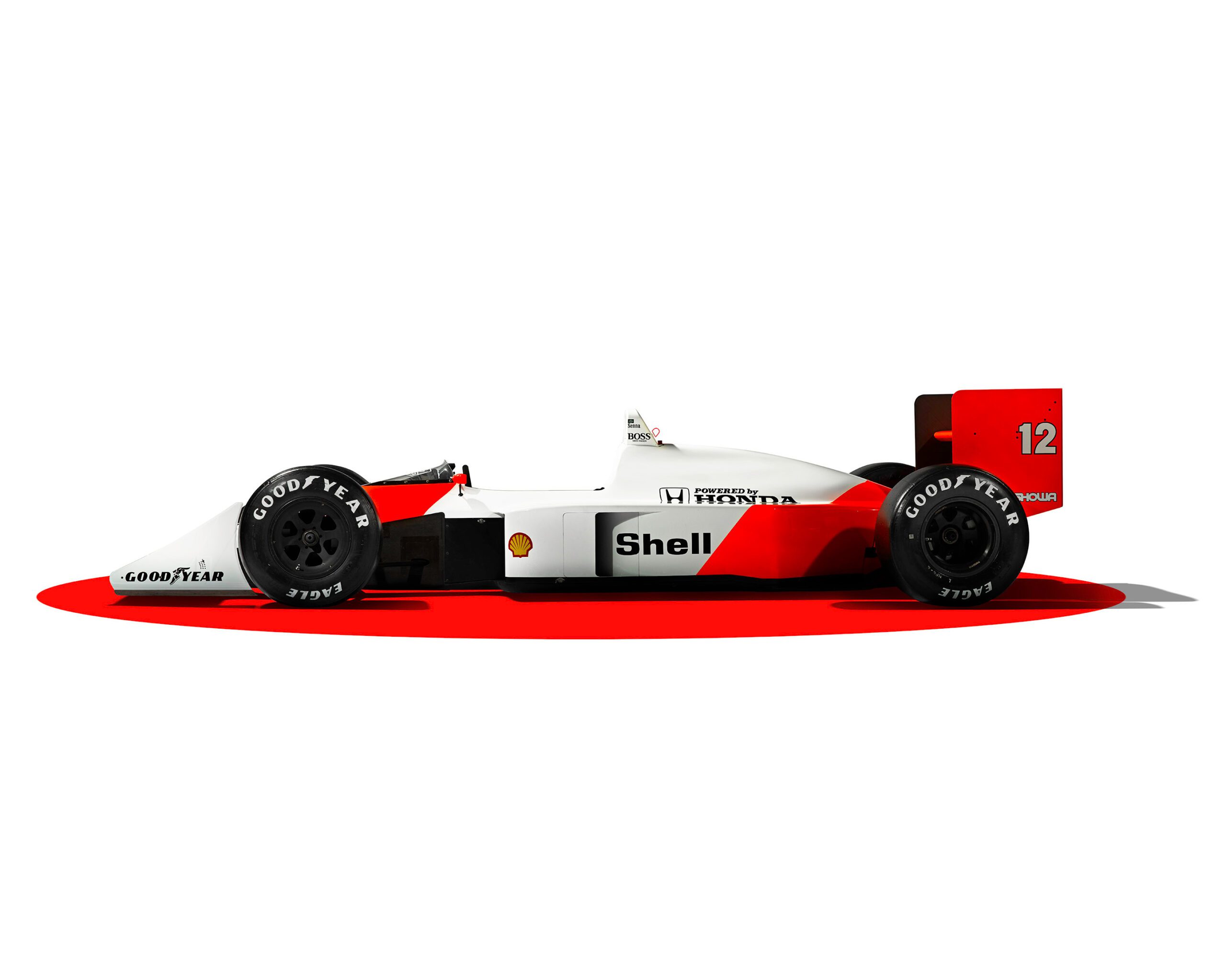 0050_807_WH_McLarenMP44_Profile_v2a Side view of Ayrton Senna’s McLaren MP44, a classic white and red Formula 1 race car with the number 12 on the rear wing. The car features sponsor logos for Shell, Goodyear, and Honda, highlighted on a red shadowed surface with luxury retouching.