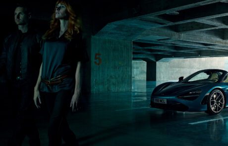 A man and woman walk away from the McLaren 720S Spyder in an underground car park.