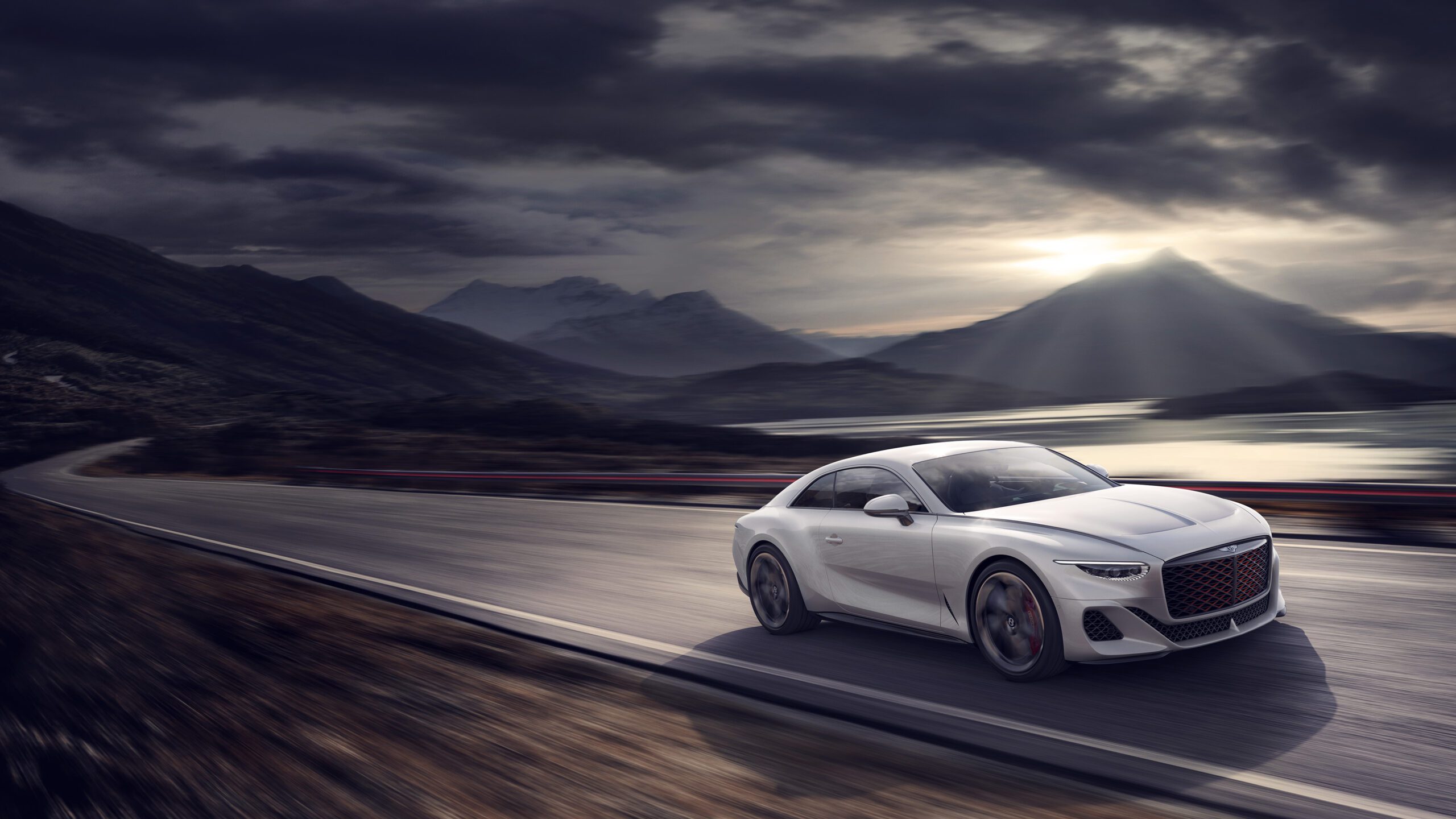 A sleek white Bentley Batur hypercar speeds along a winding mountain road under a dramatic sky with dark clouds and rays of sunlight piercing through, crafted by a masterful CGI artist. Snow-capped mountains and a reflective lake are visible in the background.