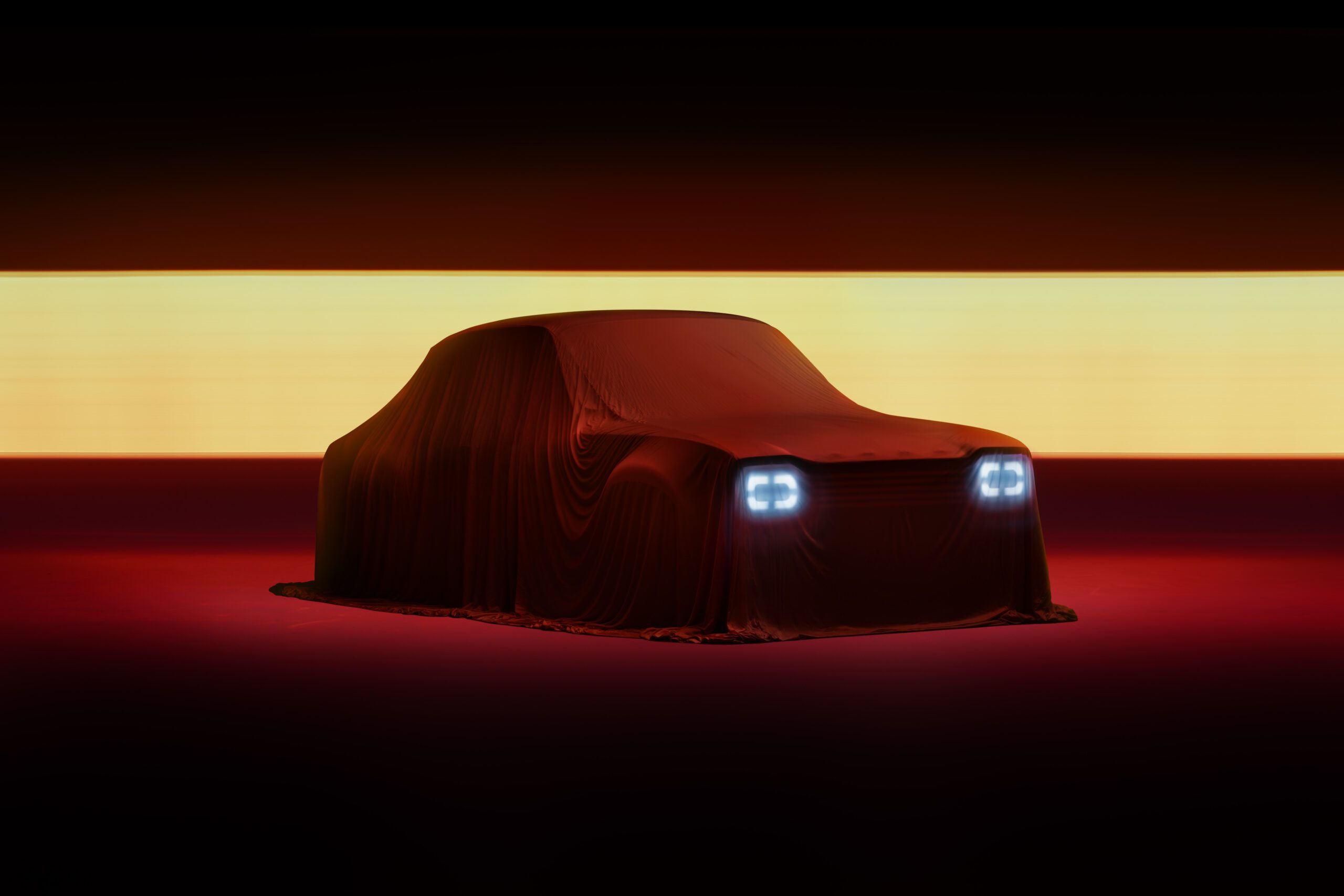 A Ford Escort MK1 DRVN is covered by a draped cloth in a dimly lit setting, with bright headlights glowing through the fabric. The background is dark with a horizontal strip of light behind the car, giving it a mysterious and dramatic appearance—an automotive retoucher's dream canvas.