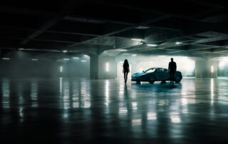 mclaren 720s parked A man and woman stand beside the McLaren 720S Spyder in a dramatically lit underground car park.