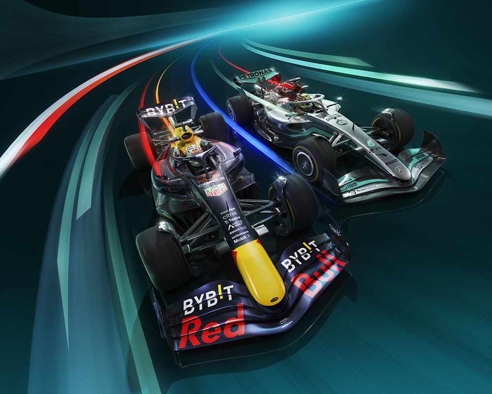 Two Formula 1 cars race side by side, leaving streaks of light behind them in a CGI masterpiece. The car on the left is predominantly dark blue with red and yellow accents, while the car on the right is silver and black. Both cars appear to be moving at high speed on a curved track, as seen on Sky F1.