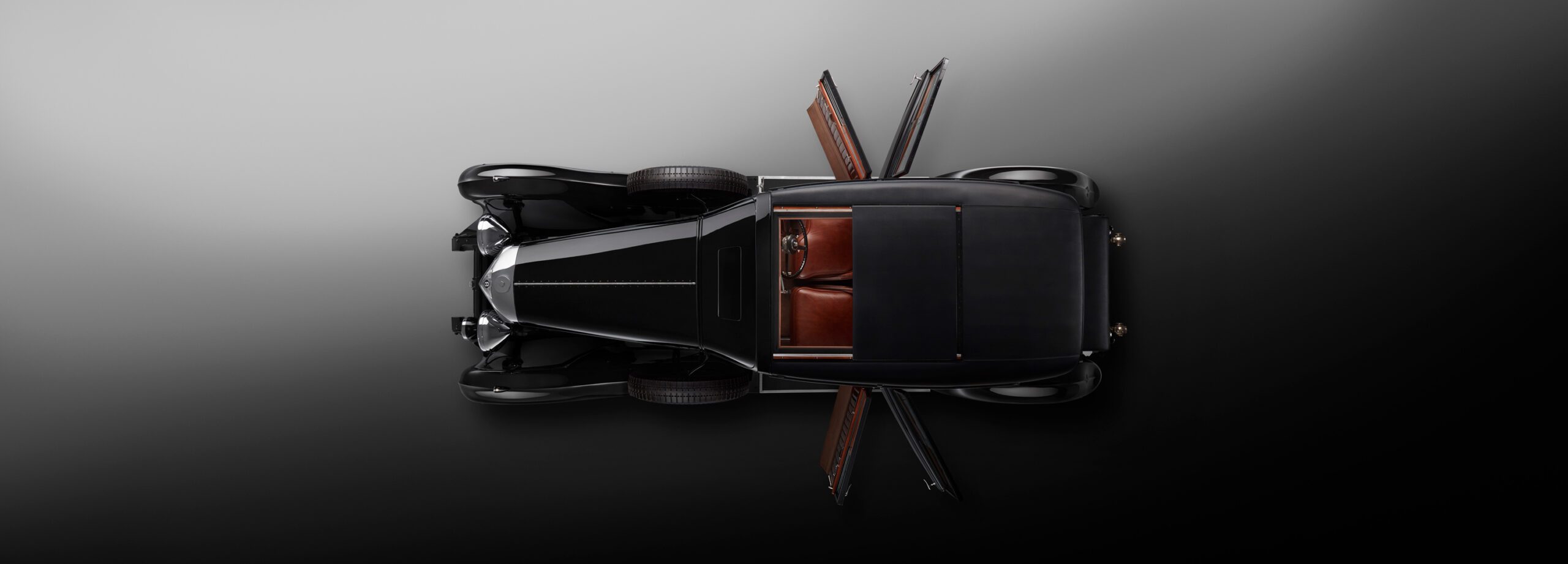 A top-down view of a WO Bentley's own 8 litre black car with open suicide doors, showcasing brown leather interior seats and minimalist design on a dark gradient background. The car has polished metallic accents and classic styling elements.