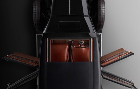 Aerial view of a WO Bentley's 8 litre car. The car doors are open, showcasing the refined interior design. The symmetrical layout emphasizes the sleek lines and classic style of the vehicle, as if meticulously captured by a skilled retoucher.