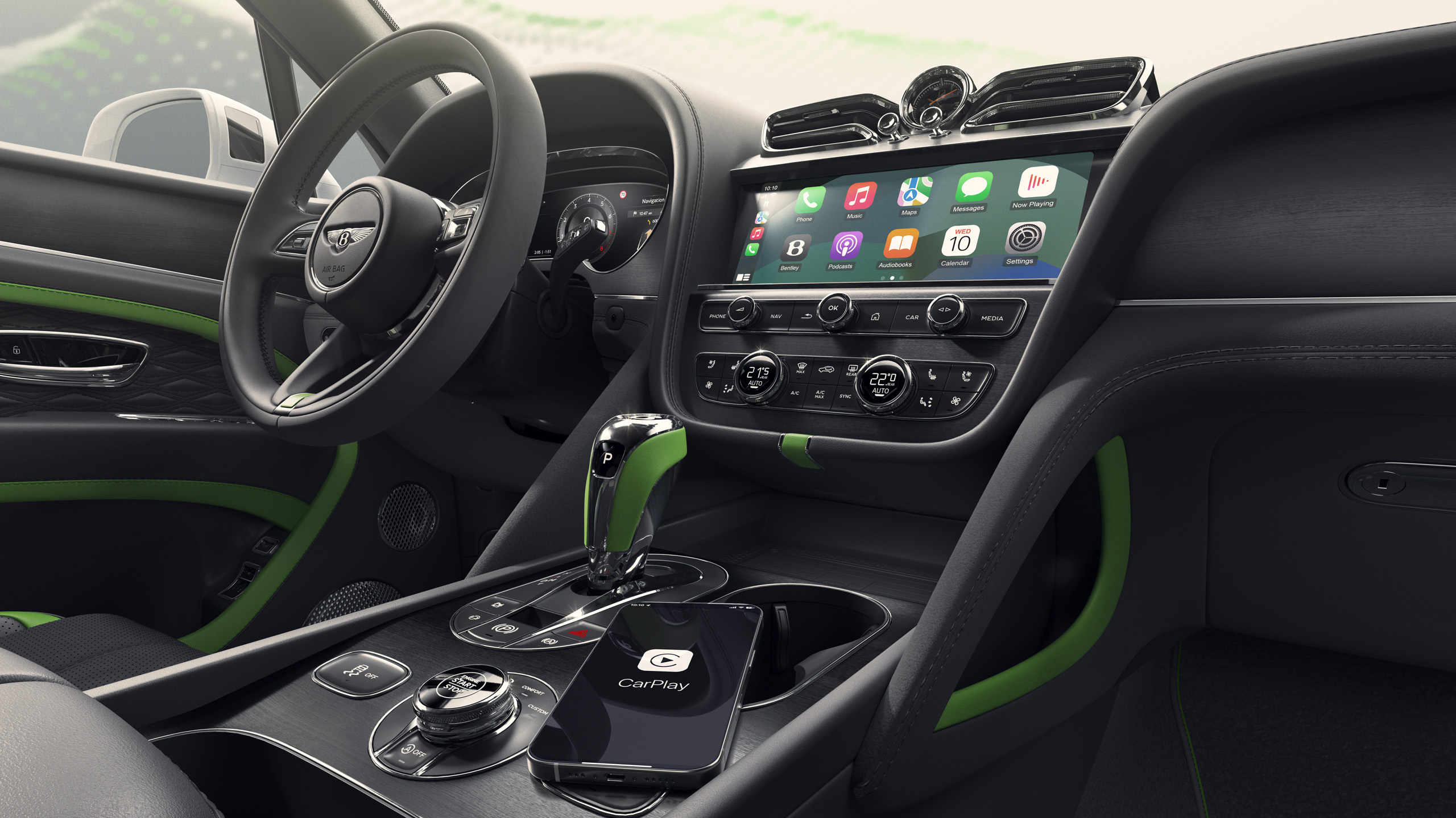 Close-up of a luxury car’s interior featuring a digital dashboard, green accents, a touchscreen displaying smartphone apps, a gear shift, steering wheel, and a smartphone on the console showing the CarPlay logo.