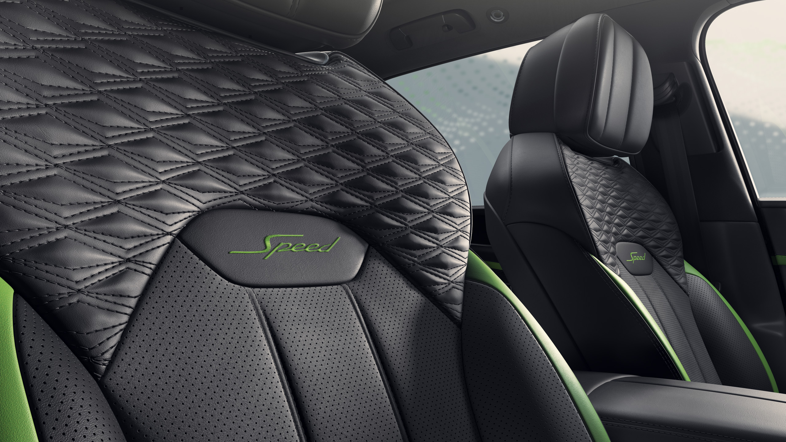 Close-up of luxury car seats featuring black leather with diamond stitching, green accents, and the word “Speed” embroidered on the headrests. The interior looks modern and stylish.