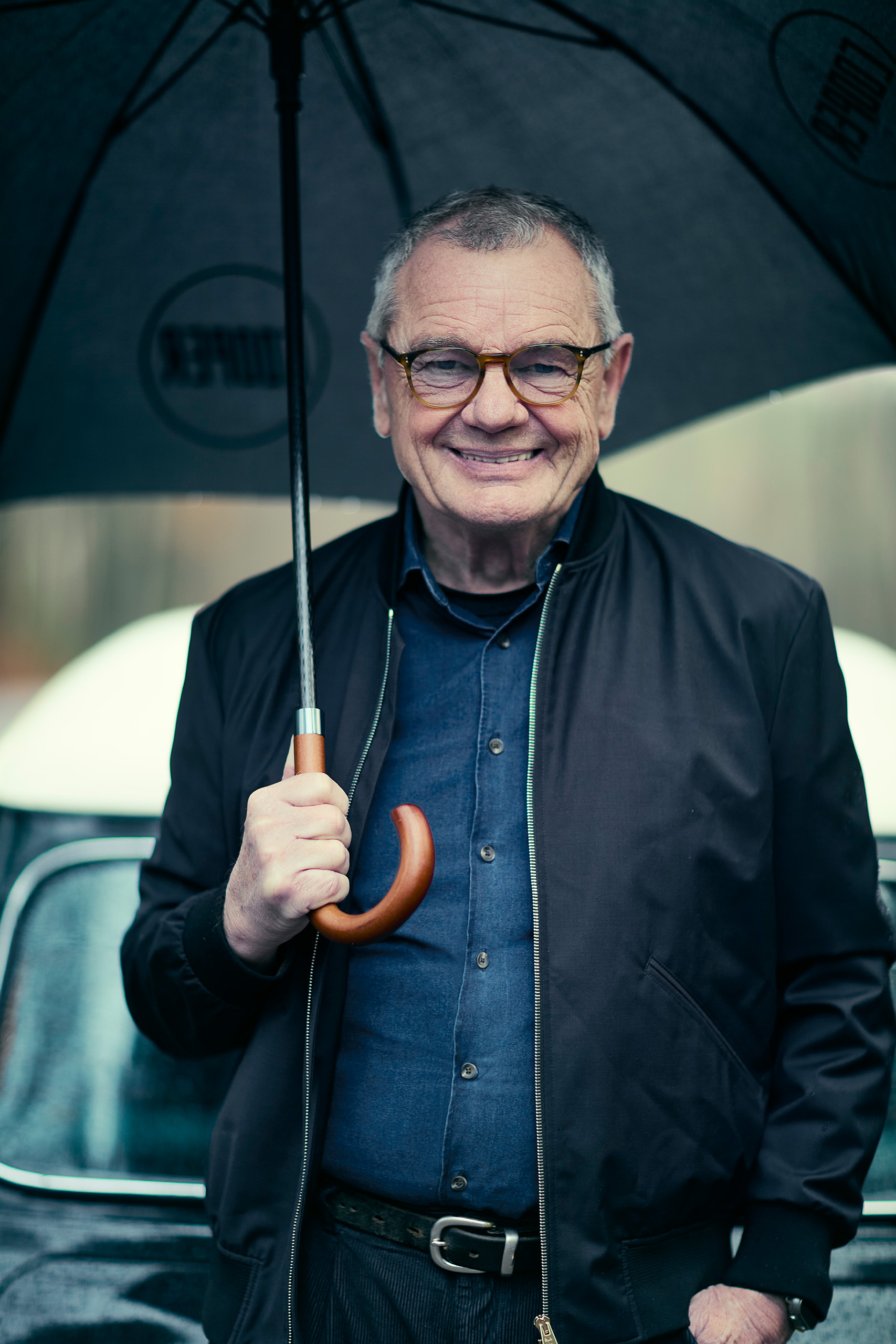 mike-cooper-obe-portrait-mini-cooper-shoot Close-up portrait of Mike Cooper OBE holding an umbrella during the on-location Mini Cooper Grand Prix shoot