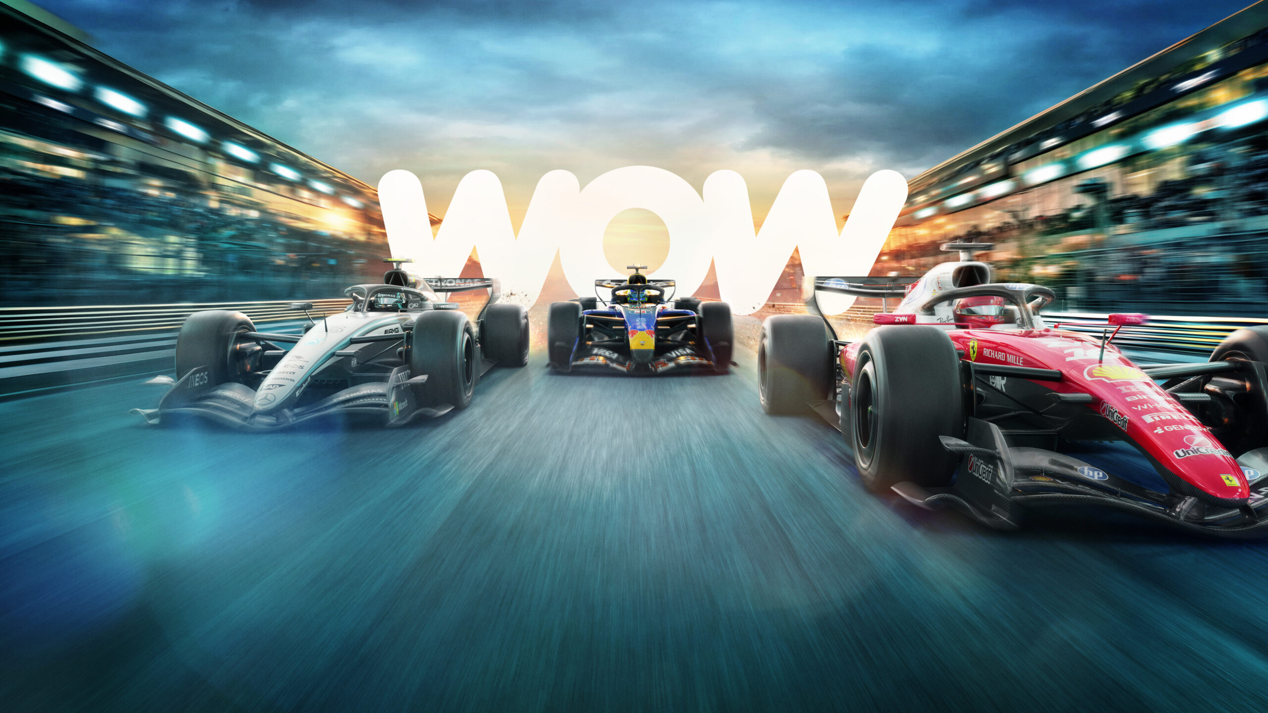 1389_1378_FI_SHARP_BG_DR_V9_v8a_v3c_TONY_16x9 Three Formula 1 cars race side by side on a track at sunset, with the word “WOW” glowing brightly in the background, emphasising excitement and speed.