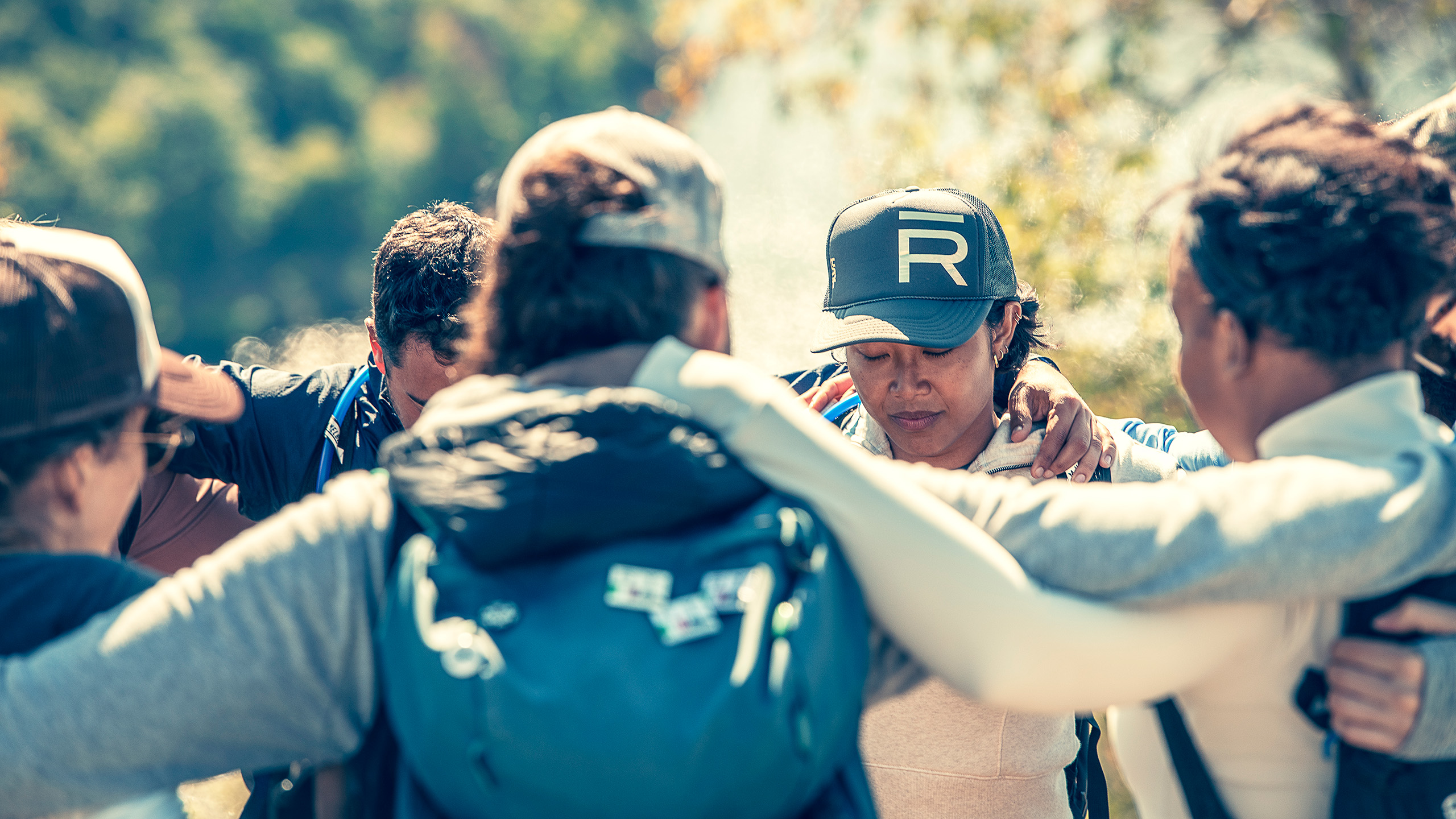 the-ranch-hudson-valley-group-huddle-hike Hikers gather in a supportive huddle on the trail at The Ranch wellness retreat, New York State.