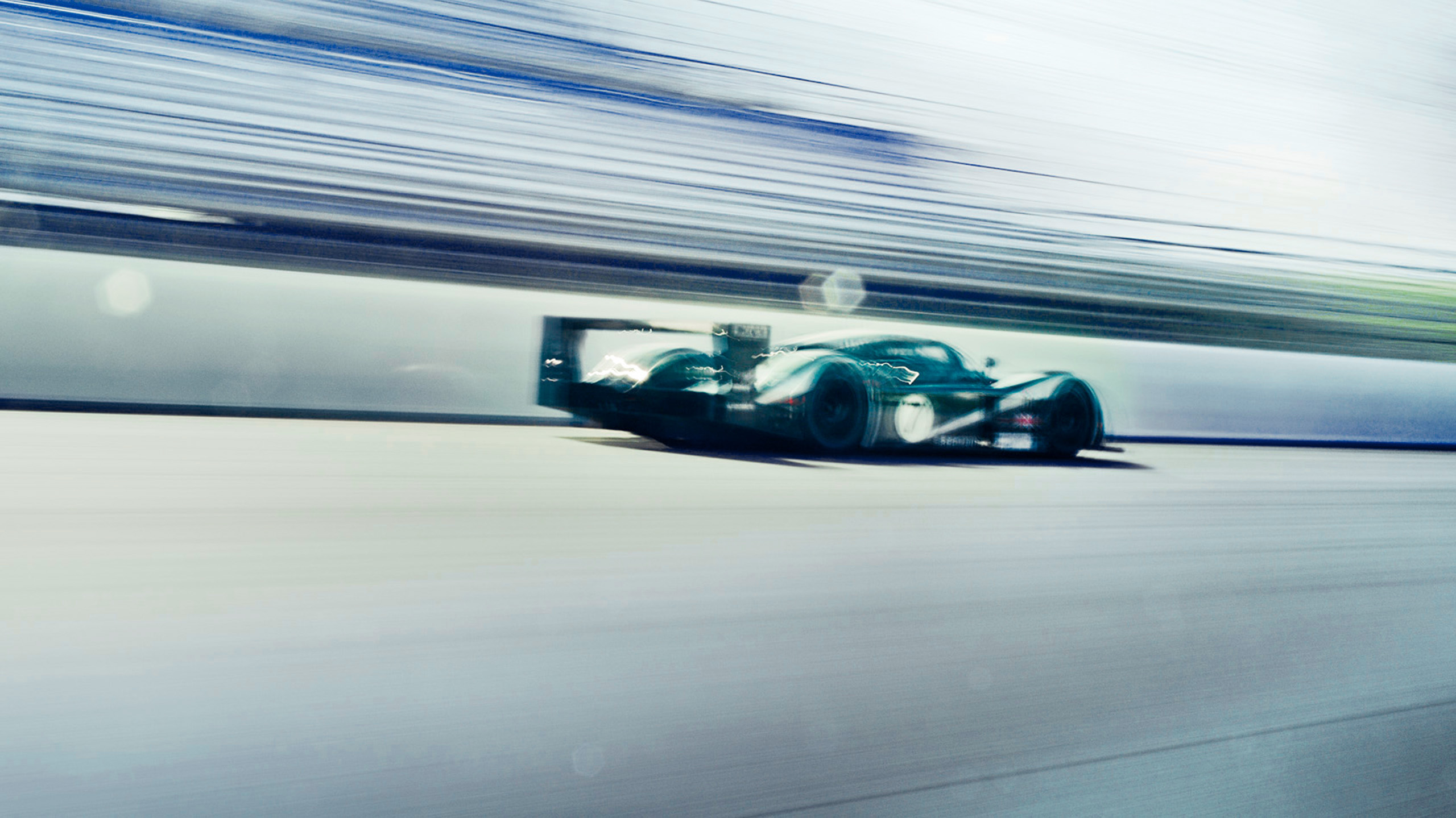 bentley-speed-8-le-mans-prototype-side-profile-cornering Side profile of a Bentley Speed 8 Le Mans prototype cornering hard, red taillights glowing through the motion blur.