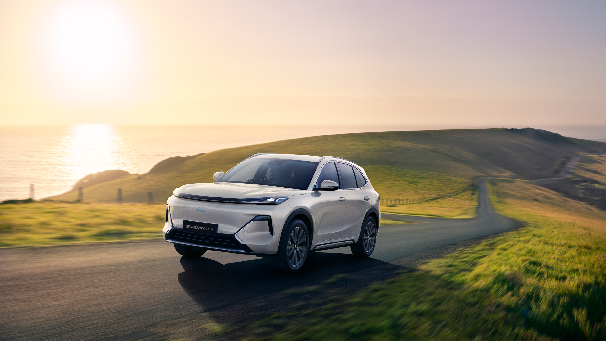 geely-starray-emi-coastal-hillside-sunrise-16×9 The Geely Starray EM-i on a coastal hillside road at sunrise, square crop for social media.