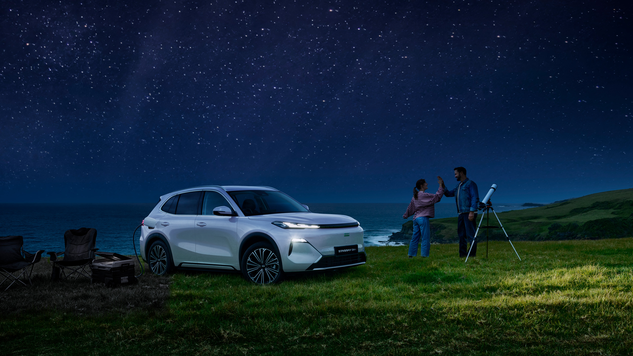 geely-starray-emi-stargazing-coastal-night The Geely Starray EM-i parked on a coastal clifftop at night in Australia, powering camp equipment while a couple stargaze with a telescope.