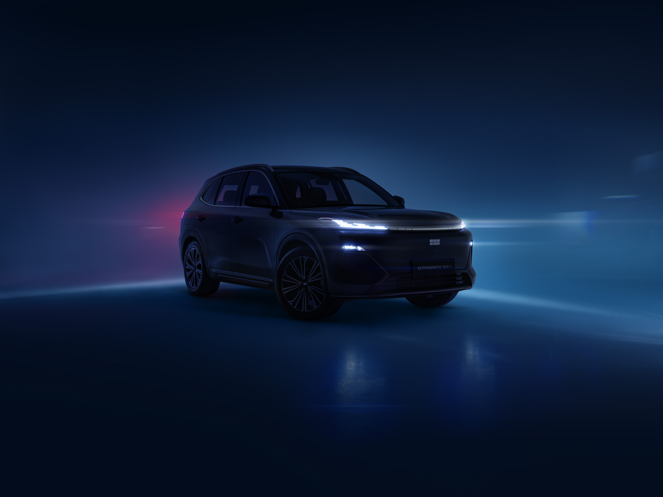 geely-starray-emi-teaser-front-three-quarter Pre-launch teaser image of the Geely Starray EM-i, front three-quarter view, headlights glowing against a dark backdrop.