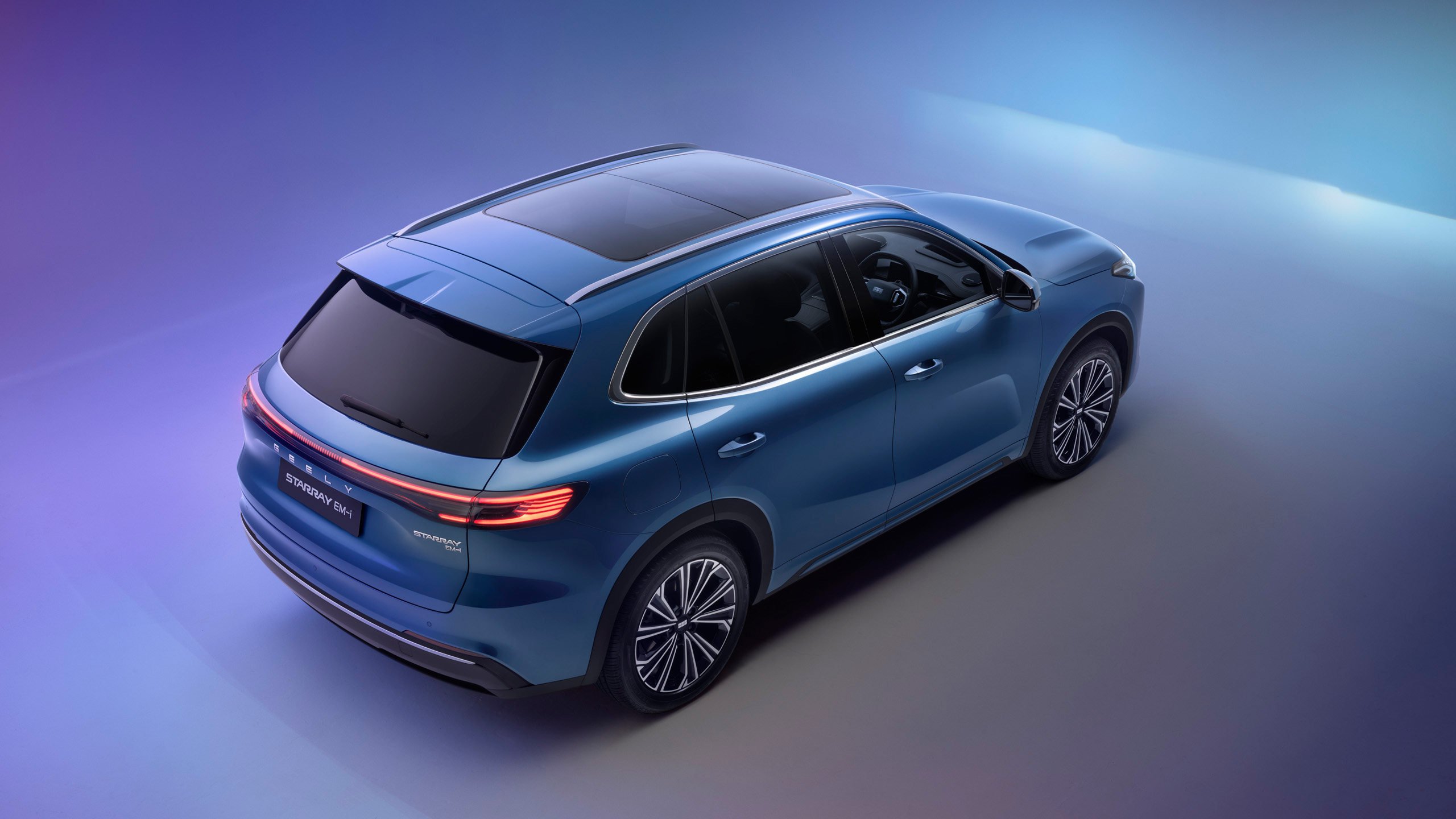 geely-starray-emi-top-shot-studio Elevated rear three-quarter studio shot of the Geely Starray EM-i, showing the roofline and glass sunroof.