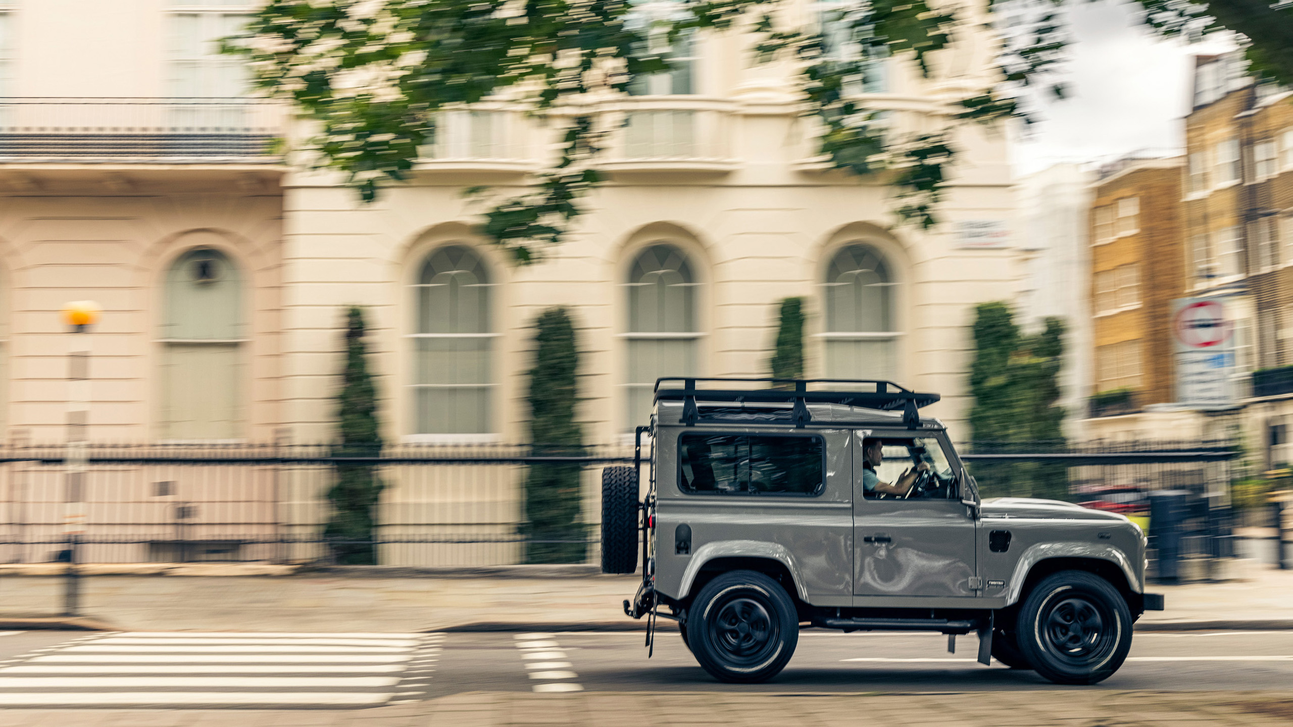 twisted-land-rover-defender-90-driving-south-kensington A grey Twisted Land Rover Defender 90 driving past townhouses in South Kensington, London.