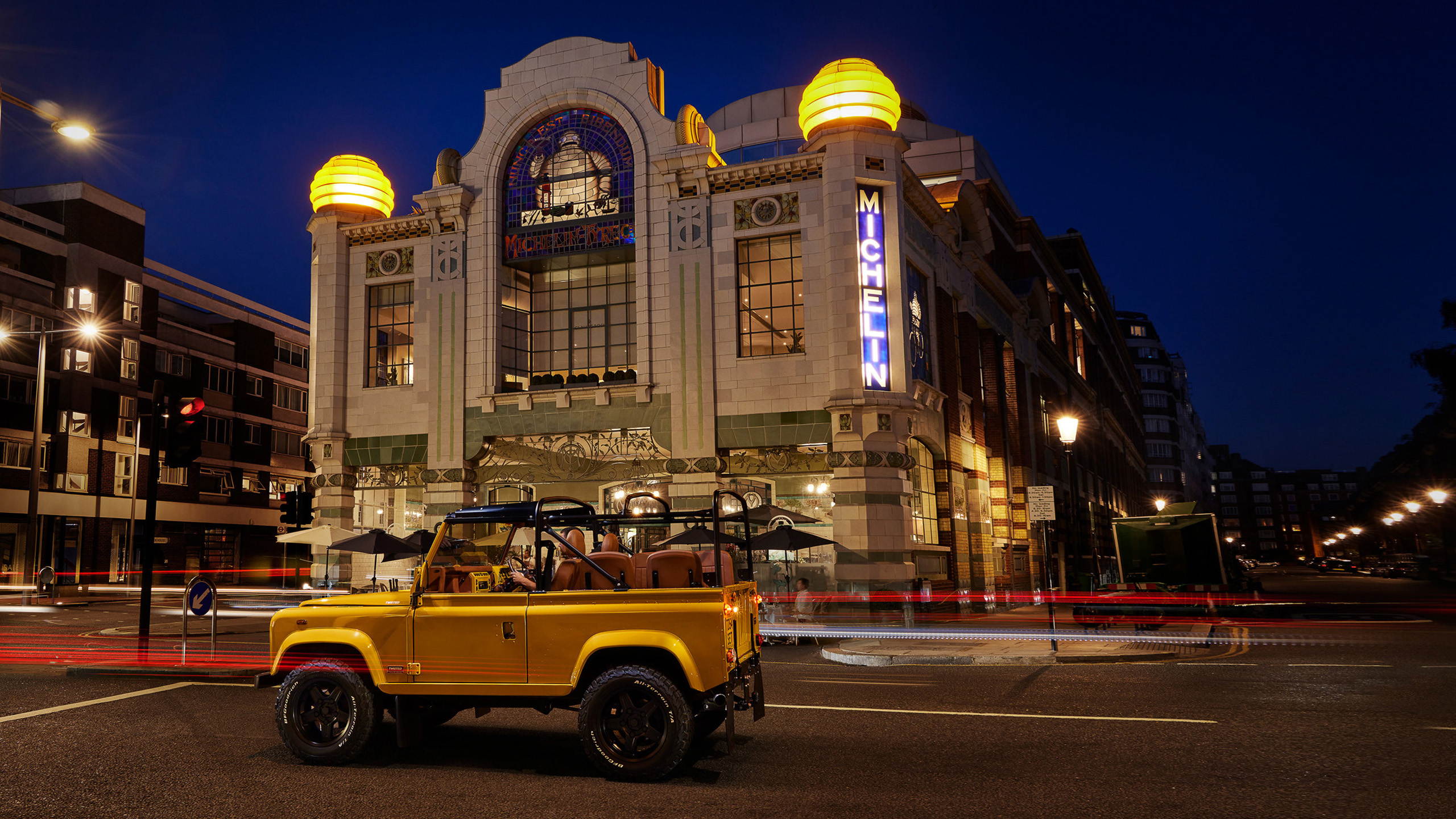 twisted-land-rover-defender-yellow-michelin-building-night A yellow Twisted Land Rover Defender parked at night outside the Michelin Building in London.